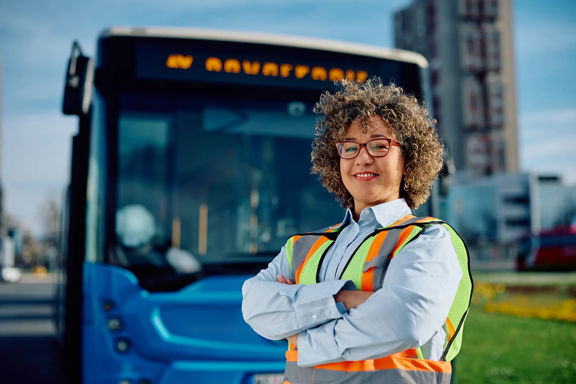 happy-female-bus-driver-with-crossed-arms-looking-2023-11-27-05-25-25-utc copia