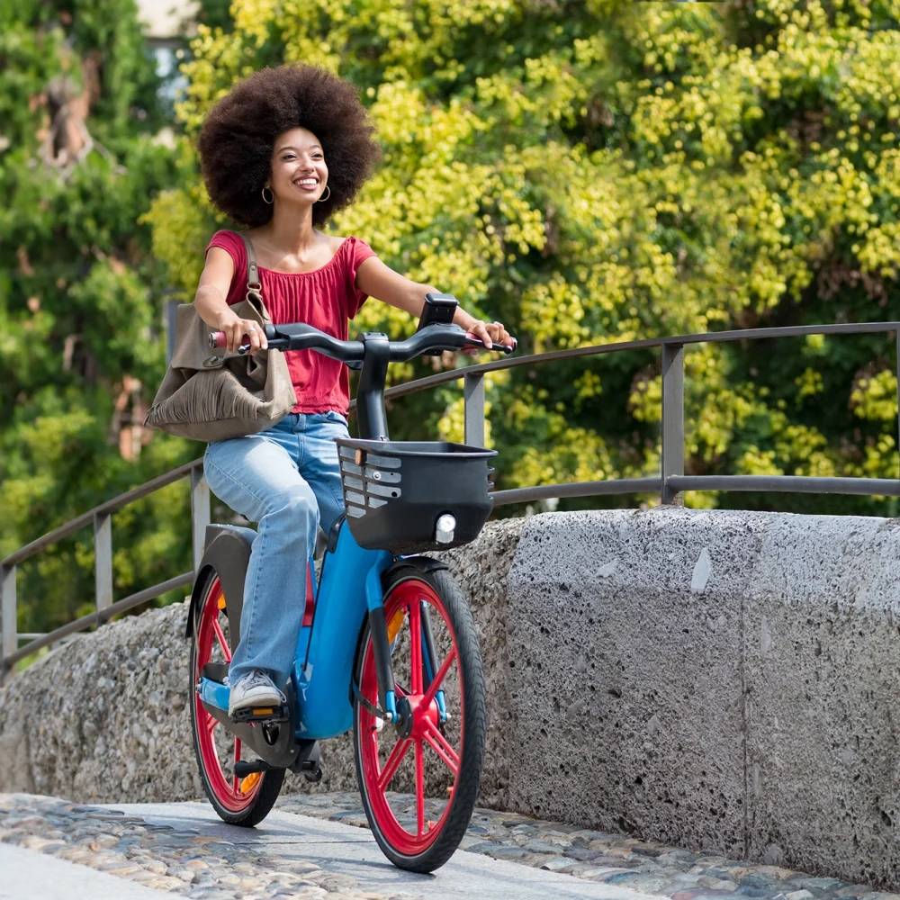 happy-black-woman-riding-electric-bicycle-on-city-2023-11-27-05-01-34-utc copia